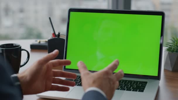 最新のオフィスでラップトップの緑の画面にビデオ通話を持っている未知のマネージャーが閉じます 専門コンサルタントは クロマキーとコンピュータを使用してオンライン会議について話しています モックアップ装置で働く男は — ストック動画