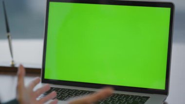 Bilinmeyen iş kadını video konferansında ofis kapanışı için laptop kullanıyor. Tanımlanamayan genç bayan yönetici web kamerası yeşil ekran bilgisayarında konuşuyor. Yeşil ekran ekranı ile çalışan kız