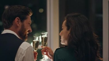 Mutlu bir çift, birlikte şampanya içerek pencereden gece manzarasının keyfini çıkarıyorlar. Romantik buluşmadan hoşlanan çekici bir çift. Gülümseyen adam esmer kadınla konuşurken rahatlıyor..