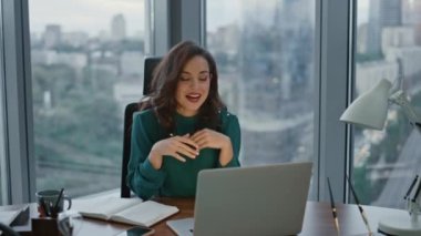 İnternet bağlantısıyla lüks bir ofiste oturan esmer yönetim kurulu başkanı online konferansta konuşuyor. İş videosu toplantısı yapan çekici bir iş kadını. Patroniçe iş meselelerini webcam 'e anlatıyor