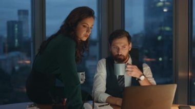 Zeki iş arkadaşları gece geç saatlerde ofiste kahve içmekten bahsediyorlar. Şirket masasında oturmuş, elinde fincanlarla iş projesini tartışan ciddi iş arkadaşları. Son teslim tarihi kavramı