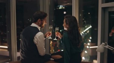 Şampanyalarını yudumlayan güzel bir çift romantik bir akşamın tadını çıkarıyor ve harika bir gece manzarası olan pencerede oturuyor. Gülümseyen bir çift birlikte kutlama yaparken şarap içerken flört ediyorlar. Mutlu aşıklar içeride gevşeyip konuşuyor.
