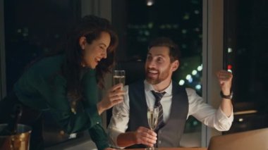 İki başarılı genç ortak, modern ofiste şampanya içerek iş başarısını kutluyor. Çekici bir iş kadını şirketiyle kutlama yapan mutlu işadamı başarılı oldu..