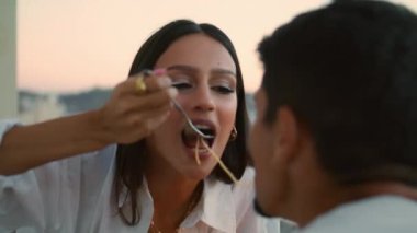 Sevimli bir çift spagetti tatmak için gün batımını yakından izliyor. Kocasının romantik yemeğini öpen tatlı bir kadın. Evlilik yıldönümü terasında yemek yiyen yeni evlilere bayılırım. Neşeli Latin eşler balkonda yemek yiyor. 