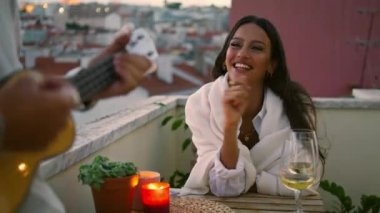 Mutlu kız akşam balkonunda el çırpıyor. Şehir manzaralı otel terasında gitar çalan isimsiz bir adam. Ukulele şarkısını dinleyen tatlı bir kadın. Romantik çift yıldönümünde birlikte dinleniyor.