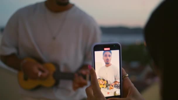 Dziewczyna Ręce Nagrywania Człowiek Gitara Odtwarzanie Wideo Tarasie Zachód Słońca — Wideo stockowe