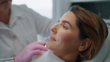 Kozmetik kliniğinde biyolojik evrim için kadın yüzü enjekte eden profesyonel bir güzellik uzmanı. Çekici bayan güzellik salonunda yüz gerdirme ameliyatı yapıyor. Botoks kolajenle yüz bakımı