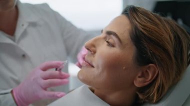 Modern kozmetik kliniğinde botulinyum terapisi yapan bir kadın. Profesyonel kozmetik uzmanı cilt tazelemek için botoks yapıyor. Çekici, sabırlı, yumuşak kırışıklıklar..