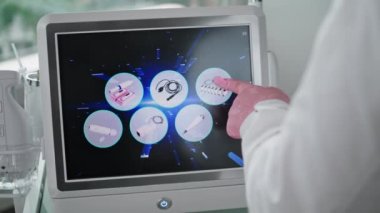 Kozmetik uzmanı, lazer kaldırma cihazındaki operasyon modlarını ayarlıyor. Bilinmeyen doktor, güzellik prosedürünü seçip ekipman ekranına dokunuyor. Modern teknoloji kozmetoloji kliniğinde.