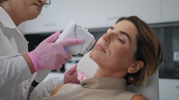 在美容院接受超声治疗的迷人女人非常接近 美容师对病人面部皮肤进行超声治疗 美容师在现代门诊部进行非手术整容 — 图库视频影像