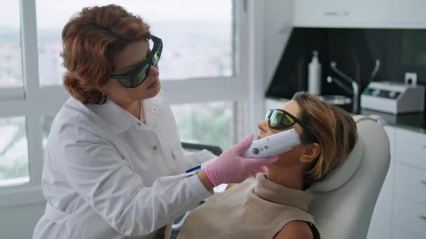Kobieta Leżąca Zabiegu Laserowym Odmładzania Nowoczesnej Klinice Kosmetologicznej Profesjonalny Kosmetyczka — Wideo stockowe
