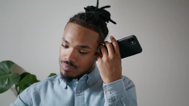 注意的自由职业者使用智能手机室内特写 现代专业的听力语音信息单独 非洲裔美国人试图理解 混淆不清的男人粘在扩音器上 — 图库视频影像