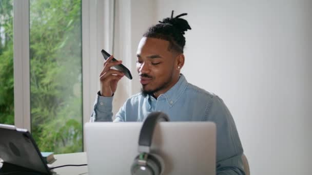 現代のアレンジャーは 自宅のオフィスの閉鎖でモバイルを話す 正の音楽プロデューサーはスマートフォンの音声メッセージを記録します アフリカ系アメリカ人の男が遠隔スタジオで働いてる — ストック動画