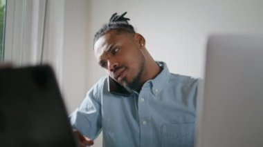 Kapalı gişede telefonla konuşmakla meşgul. Ev işyerinde laptopta çalışan Afrikalı Amerikalı bir adam çağrıya cevap veriyor. Hippi adamın teslim tarihine az kaldı. İlgili uzman çözme sorunları 