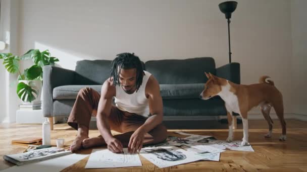 现代艺术家把镜头拉近了 有才华的男人在公寓里和家养的狗拍照非洲裔美国画家独自创作抽象的草图 职业业余爱好概念 — 图库视频影像