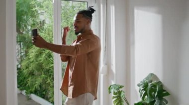 İç çekimde telefonla konuşan genç bir adam. Başarılı bir adam, evdeki iş arkadaşlarıyla akıllı telefon görüşmeleri yapıyor. Sanal aramada cep telefonuyla konuşan Afrikalı Amerikalı serbest yazar