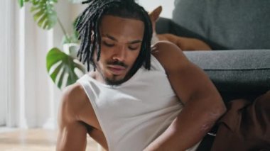 Odaklanmış ressam, evi yakından çekiyor. Konforlu oturma odasında resim çizen Afrikalı Amerikalı bir adam. Köpek kanepede yatan çağdaş bir adam. Modern sanatçı tek başına eğleniyor.
