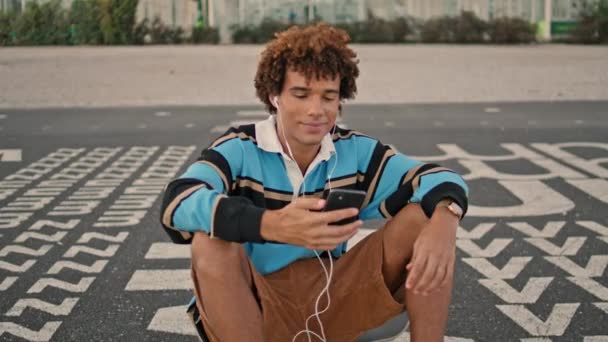 Smiling Zoomer Shooting Smartphone Street Closeup Earphones Guy Listening Music — Vídeo de stock