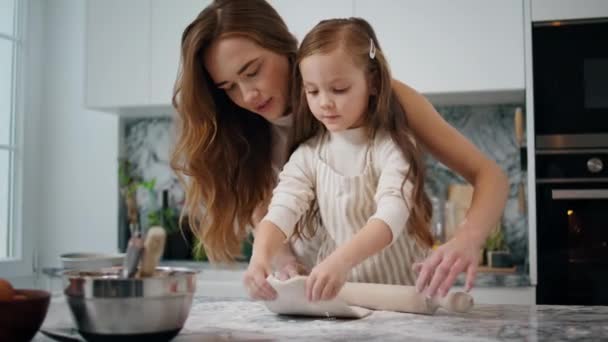 让家人在家里做面团 温柔的母亲在厨房帮助孩子 可爱的学龄前女孩做糕点结合千禧年的妈妈 家庭食品和小助手概念 — 图库视频影像
