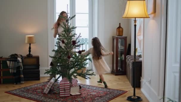 Активная Семья Играет Новогодней Ёлке Позитивная Мать Убегает Дочери Украшенном — стоковое видео