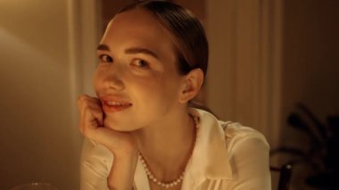 Baştan çıkarıcı kadın akşam evde kameraya bakıyor. Mumlara poz veren flörtçü bir kız. İçindeki karanlık tutkuyla bakan duygusal model. Rahatlamış bir bayan, kafasının üstünde oturuyor.