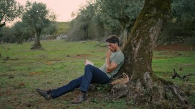 Sakin çiftçi kırsal kesimde günbatımında kitap okuyor. Rahat adam zeytin ağacının altında romandan zevk alıyor. Çimenli kırlarda hobilerine ara veren dinlenen bahçıvan. Çiftlik konseptinde hasat. 
