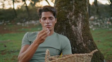 Gün batımı çiftliğinde zeytin kokusu alan tatmin olmuş bahçıvan. Gülen adam yosunlu ağaç doğasının kalitesini ölçüyor. Neşeli çiftçi elinde sepetle bitkileri inceliyor. Petrol üretim hasat konsepti 