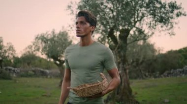 Gün batımında yorgun adam hasadı yakın plan. Bronzlaşmış çiftçi akşam bahçesinde ağaca bakıyor. Büyük bir fidanlıkta zeytin yetiştiren sakin bir işçi. Yakışıklı bahçıvan bahçedeki bitkileri inceliyor.