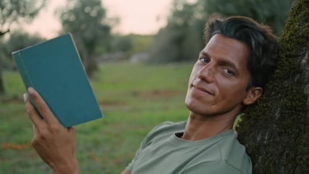 Tipo Sonriente Sosteniendo Libro Retrato Sunset Park Hombre Adulto Positivo — Vídeo de stock