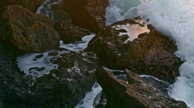 Sea splashing crag nature at morning closeup. Huge waves crashing volcanic rocks at ocean shore. Cinematic foamy water violently breaking over stoned coast of exotic island. Marine landscape concept 