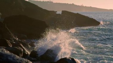 Abundant ocean crushing crag nature at summer closeup. Splashing water washing mountain at sunny morning. Wild waves breaking at stone cliff environment. Warm light reflecting at aqua landscape