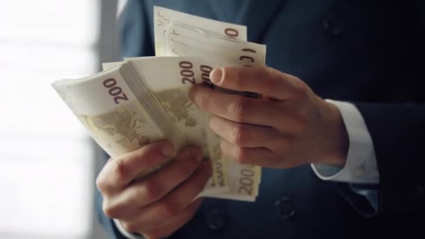 持有欧洲货币现钞的男性手拉近了距离 不知名的商人在室内清点200欧元的钞票 银行业投资财政利润财富概念 — 图库视频影像