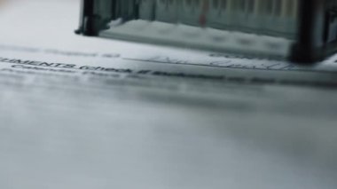 Top secret sign stamping on important official document close up. Unknown person hand holding seal verifying confidential papers indoors. Confirmation classified documentation. Paperwork concept.