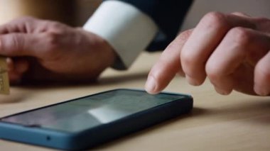Man hand entering credit card number in mobile app making online purchase close up. Unrecognizable client paying distantly typing bank data on smartphone. Internet e-commerce payment application. 