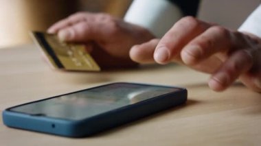 Unknown man entering credit card data in smartphone close up. Male hands typing bank information in phone app. Businessman using virtual money for paying online service internet shopping. Safe payment