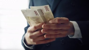 Avrupai nakit paraları sayan bir adam ellerini kapalı mekanda tutuyor. Paket banknotlarını hesaplayan tanınmamış zarif bir işadamı 200 euro değerinde. Genç finansör iş yatırımlarından kâr elde ediyor.