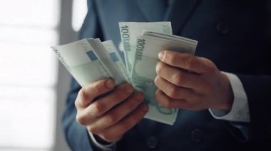 Finansist hands holding european currency denomination of hundred close up. Unknown business man counting euro banknotes. Successful manager having pack of cash. Salary investment profit concept.