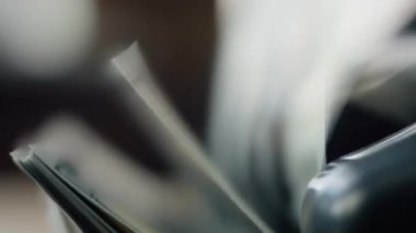 Macro shot counter counting bills american currency indoors. Automatic machine calculating money cash for business operation close up. Wad of hundred dollars accumulating in electronic equipment.