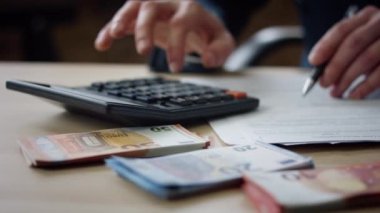 Man hands pressing calculator buttons counting tax financial bills closeup. Unknown financier calculating business income outcome indoors. Accountant working with documents at desk. Budget concept.