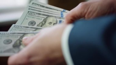 Banker hands counting american currency bills denomination of hundred dollars close up. Unknown businessman in dark suit calculating pack of money cash. Business finance accounting savings concept.
