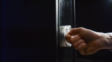Man hand closing metal strongbox door close up. Unknown person entering numbers combination on electronic panel to lock modern safe. Male fingers pressing locker buttons using correct pass code.