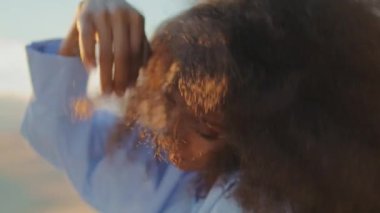 Yaz akşamları çölde şehvetle dans eden çekici Afro-Amerikan kadın portresi. Parlak modern makyajlı nazik kız dansçı yumuşak vücut hareketleri yaparak doğaya yakın çekim yapıyor..