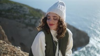 Uçurumun kenarında müzik dinleyen tatmin olmuş bir kadın. Mutlu kız gözlerini kapayıp bahar güneşinde dinleniyor. Kaygısız turist öğrenci sakin atmosferin tadını çıkarıyor deniz manzarasına hayran. Rüya gören güzel bayan.