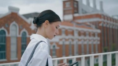 Focused young businesswoman walking street messaging on smartphone closeup. Confident serious woman manager typing sms on go outdoors. Side view of attractive elegant girl with mobile hurrying to work