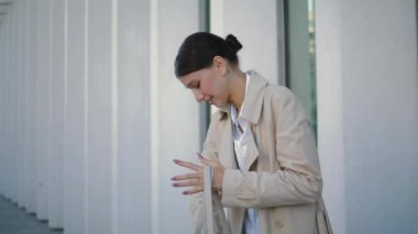 Ofis binasının yanında duran çantada telefona bakan meşgul bir iş kadını. Çekici genç bir kadın ekrandan el çantasından akıllı telefonu alıyor. Sokaklarda modern cep telefonu kullanan zarif bir kız..