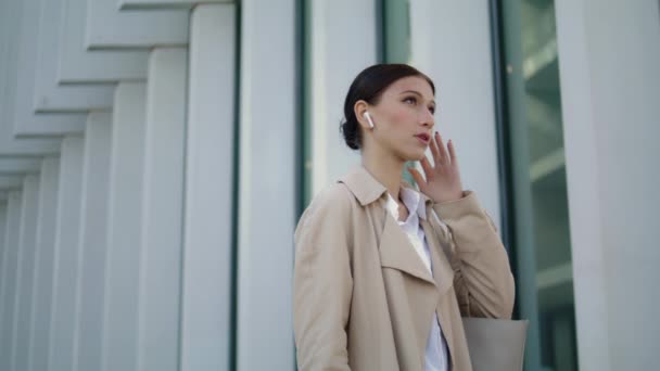 Busy Woman Speaking Wireless Earbuds Standing Modern City Building Close — Stockvideo