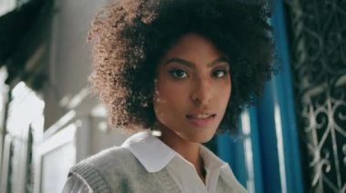 Sakin, nazik genç bir kadın güzel şehir binalarında yavaşça yürüyor ve kameraya yakından bakıyor. Çekici, şehvetli, Afro-Amerikalı kız sakin, güneşli bir günün tadını çıkar. Baştan çıkarıcı zarif modelin portresi