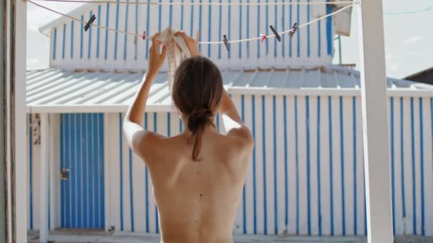 海滩女孩把比基尼胸罩挂在烘干机的后视镜上 无忧无虑的女人赤身裸体在海滨享受阳光 不为人知的瘦弱游客享受暑假 海滨野营活动概念 — 图库视频影像