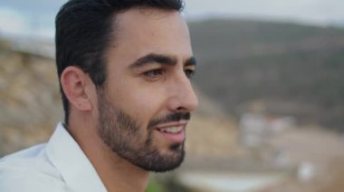Handsome guy smiling camera at misty beach closeup. Positive man standing alone at foggy day. Cheerful male model posing at ocean shore portrait. Unshaven tourist face emotions outdoors at nature 