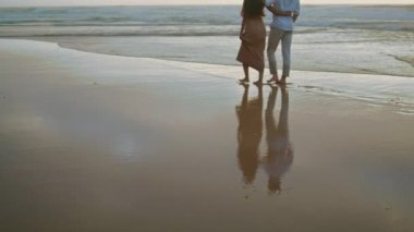 Couple legs crossing ocean at summer closeup. Affectionate married people enjoying seashore. Positive newlyweds spending honeymoon together. Embracing lovers rest at foggy coast. Vacation concept 